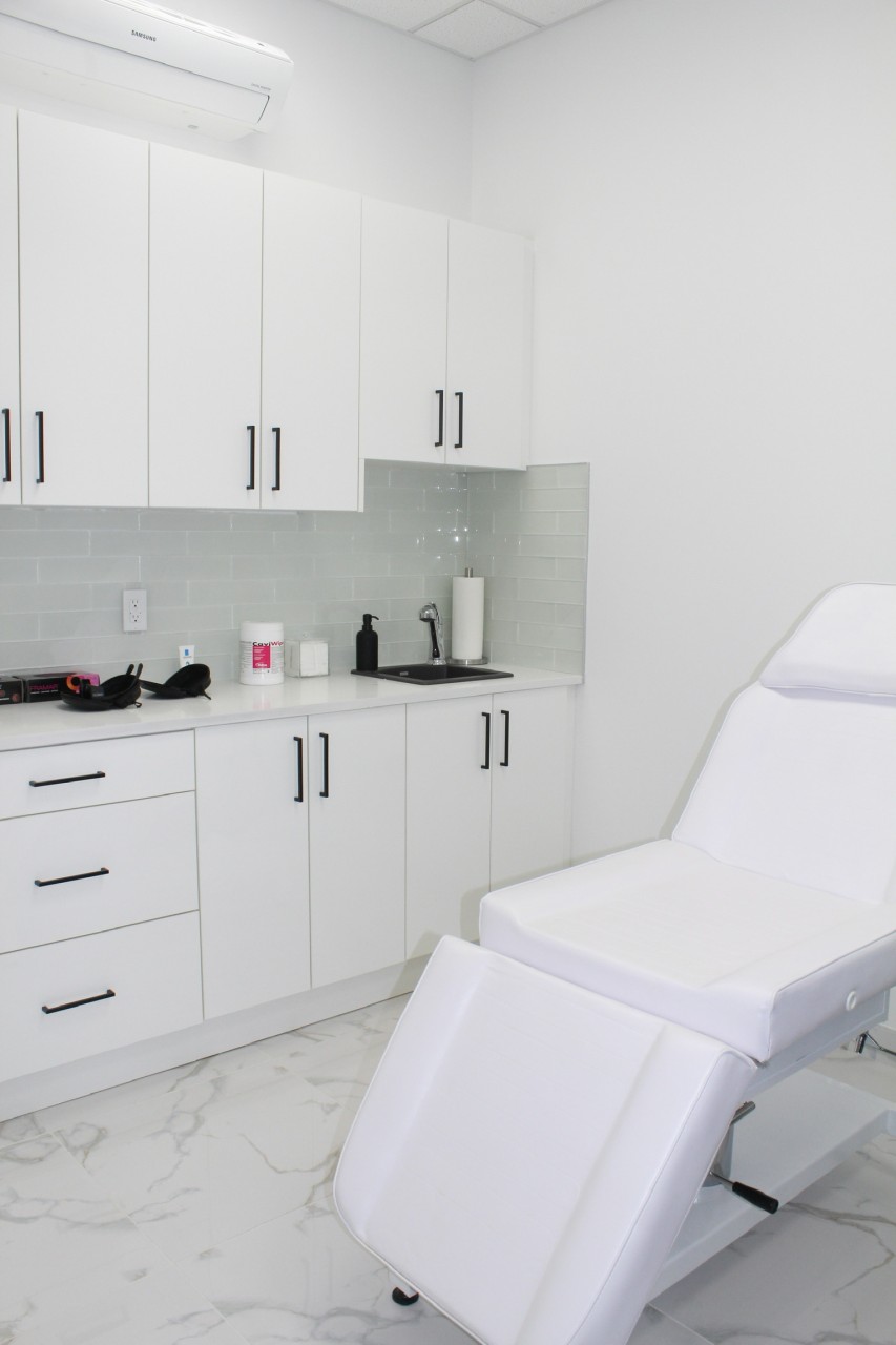 dentist procedure room with white cabinets and white chair